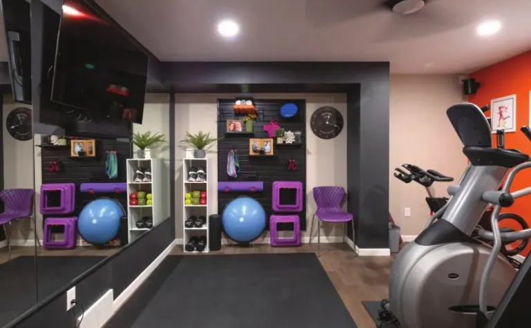 Basement home gym with an exercise bike, yoga balls and a mirrored wall