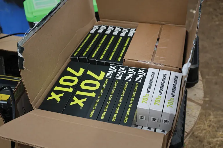 Assorted boxed magazines labeled "X10X" stacked inside an open cardboard shipping box.