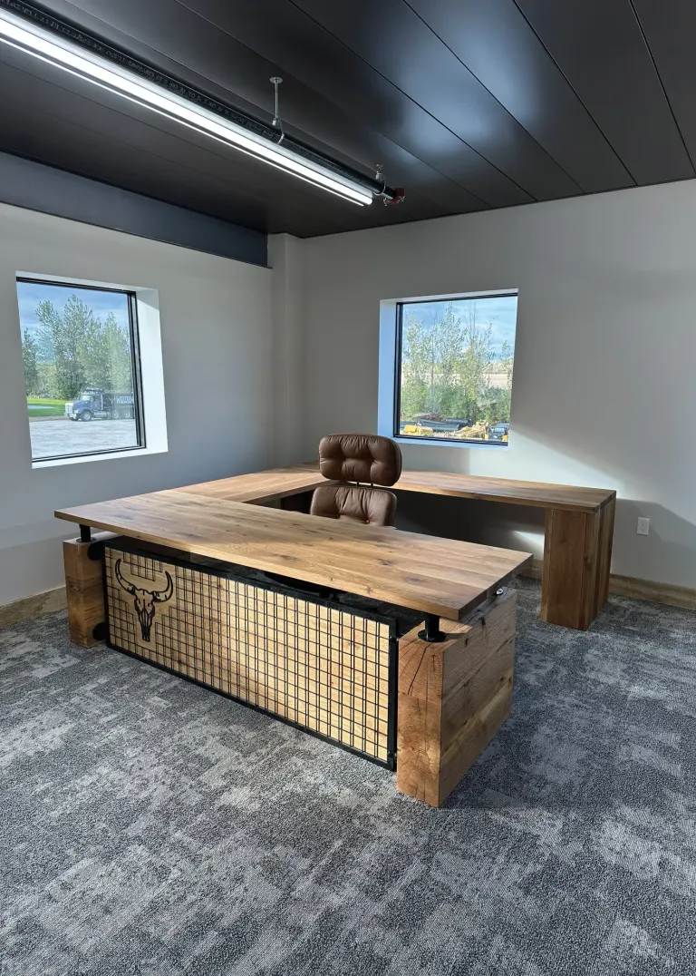 U-shaped wood desk with a metal grid front panel in an office