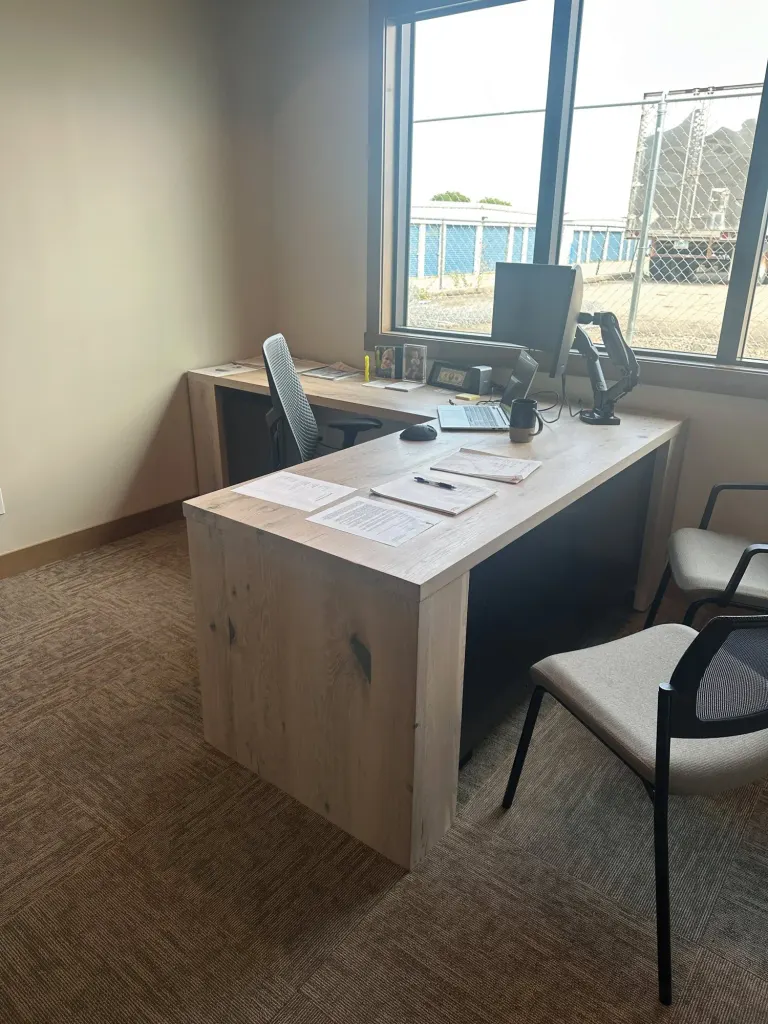 Light wood desk with a gray panel and a visitor chair
