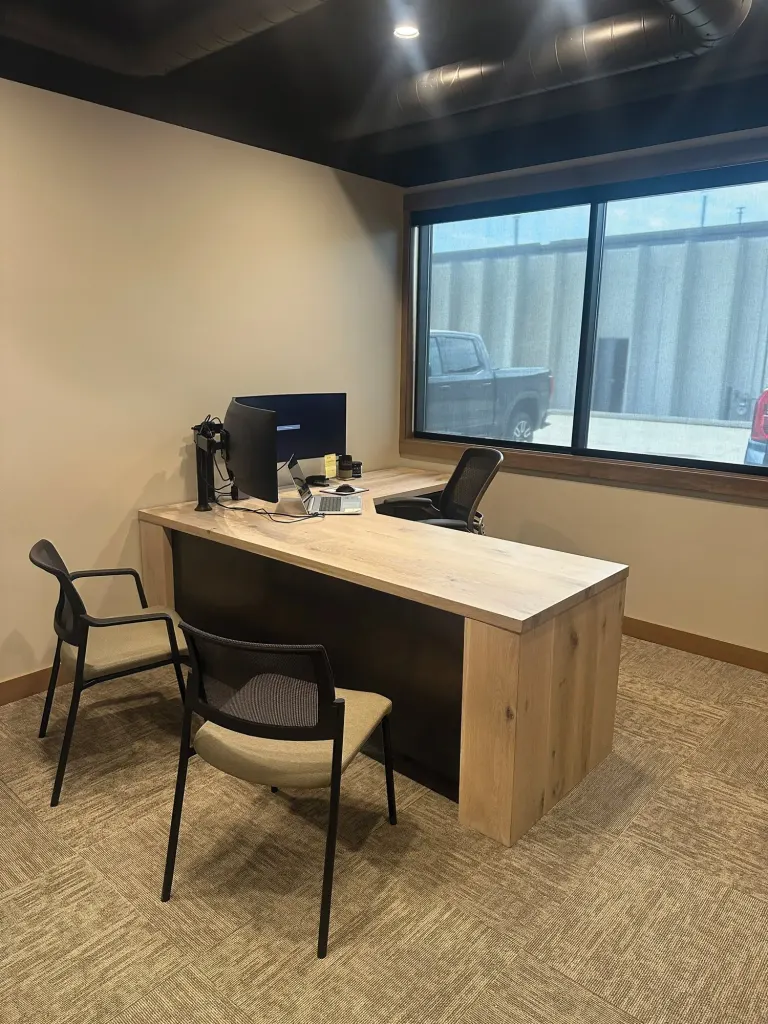 Light wood L-shaped desk with a modesty panel in an office