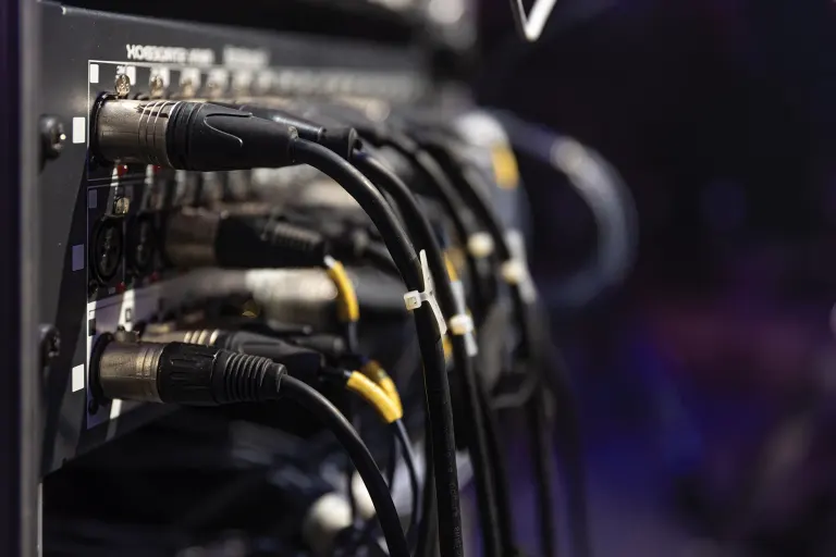 Networking rack with multiple coiled cables and connectors in a data center.