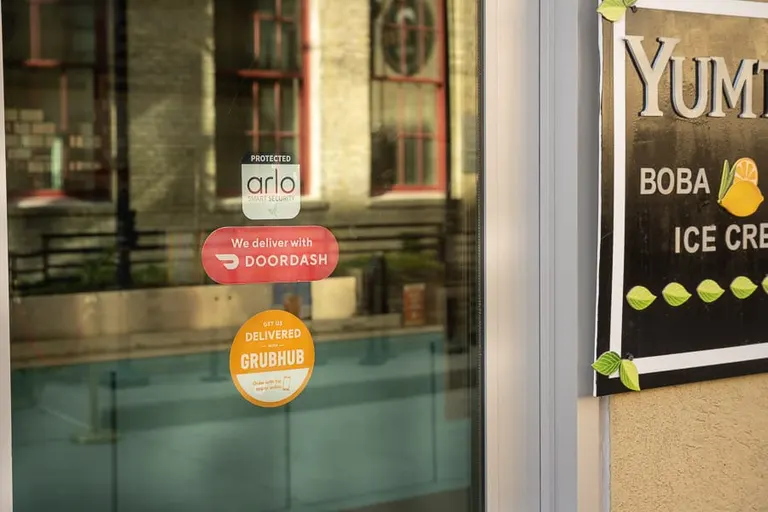 A ‘We Deliver with DoorDash’ sign at YumTea, a boba and ice cream shop in downtown Fargo, ND. DoorDash allows small businesses like YumTea to expand their reach through delivery services.