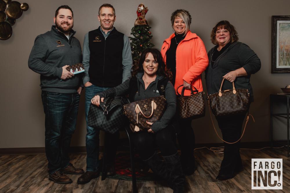 (Left to right) Ian Beaton, Todd Trottier, Nancy Kelly, Vickie Hendrickson, and Dawn Kearns pose with the Louis Vuitton bags that they got for hitting their sales goals with Labor Masters last year.
